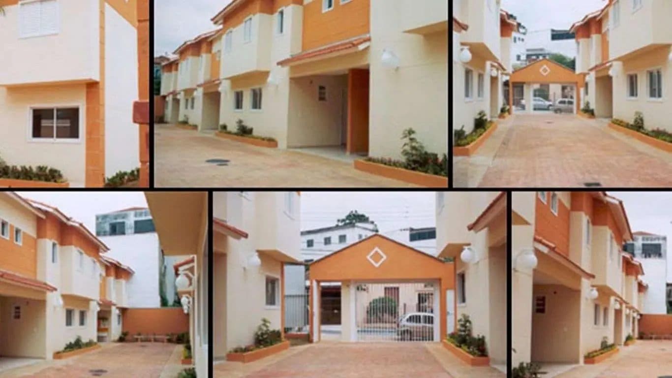 Fachada de condomínio residencial com casas de dois andares em tons de bege e laranja.