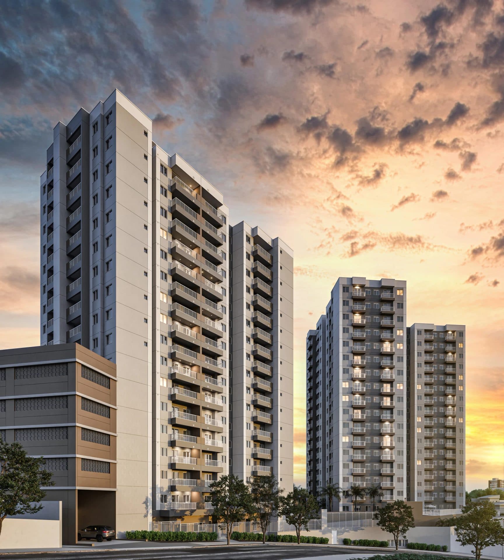 Fachada de edifícios residenciais ao entardecer com céu alaranjado.